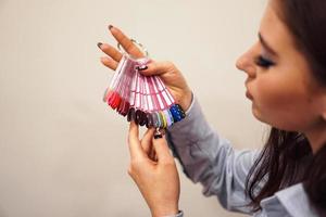 The girl chooses the color of Polish for manicure. Testers nail photo