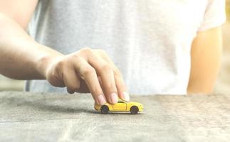 Person playing with a toy car photo