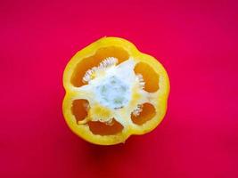 Yellow pepper on a red background photo