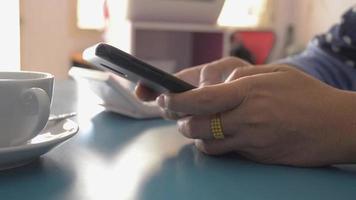 Businesswoman typing text message with cell phone on the working desk video