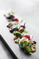 Modern gourmet creative cuisine goat cheese salad with organic marinated vegetables and figs photo