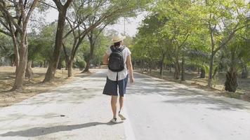 Mujer en traje casual caminando tranquilamente en el parque durante el verano video