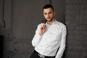 Stylish young businessman in white shirt is holding a jacket on finger photo