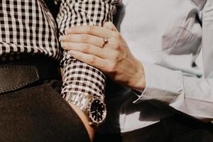 Couple of lovers holding hands. Hand with wrist watch. photo