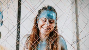 Brunette girl behind the net. Portrait of woman with blue sparkles photo