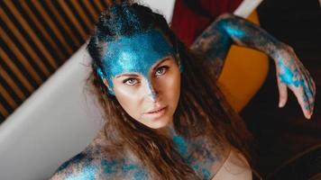 Woman with sparkles on her face. Girl with art make up photo