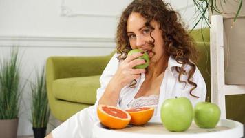 mujer comiendo manzana verde en casa. nutrición saludable, concepto de comida dietética