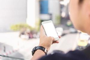 Cerca de la mano del hombre mediante teléfono móvil en la calle foto