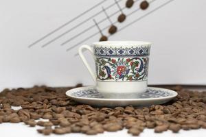 A cup of turkish coffee among the coffee grains photo