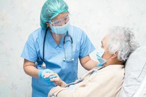 médico asiático con traje de ppe para proteger el coronavirus covid-19 foto