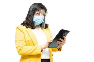 mujeres de negocios asiáticas usan tableta con máscara para proteger el coronavirus foto