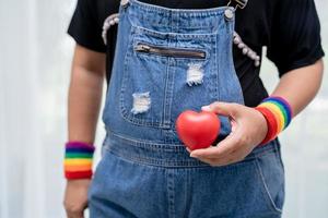 Asian wearing rainbow flag wristband symbol of LGBT pride month photo