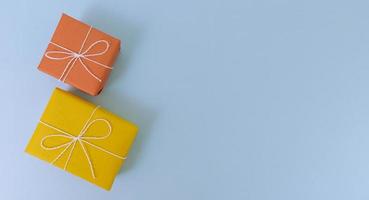 Cajas de regalo de color amarillo y naranja sobre un fondo azul. foto