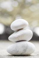 A pile of three white stones isolated in blurred background photo