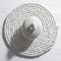 White stone on a central of white rope background photo