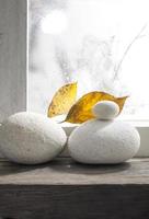 Pebble white stone with dried leaf background photo