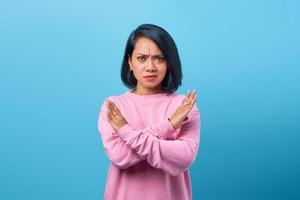 Bautiful Asian woman frowning displeased showing stop gesture photo
