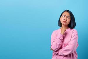 Attractive asian woman thinking and looking up empty space photo