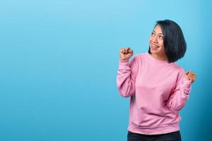 Excited woman celebrating success with two fists in the air photo