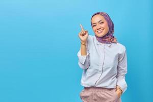 Beautiful Asian woman smile and pointing to empty space photo
