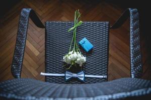 Wedding bouquet, handkerchief butterfly and gift box on the chair. photo