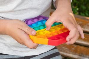 Child's playing with colorful educational toy simple dimple. photo