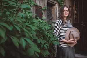 Beautiful woman in a striped shirt holding her hat photo