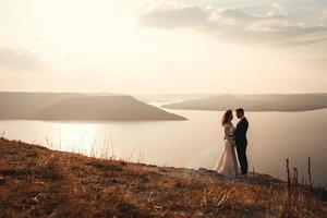 Married couple embracing on a mountain photo