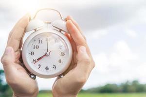 Selective focus of alarm clock with nature bokeh background. photo