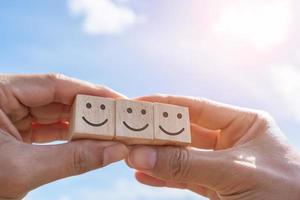 Smile face and cart icon on wood cube. Optimistic person. photo