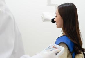 Dentista con máquina de rayos X para escanear el diente del paciente en la clínica foto