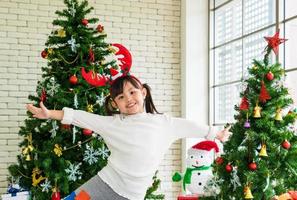 Little girl in front of Christmas tree photo