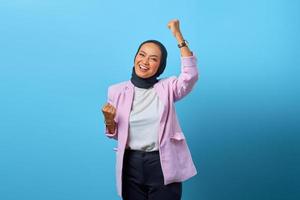 Emocionada mujer asiática celebrando el éxito con expresión de risa foto