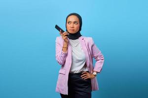 Attractive Asian woman using mobile phone over blue background photo