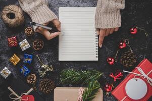 una mano sosteniendo un bolígrafo para escribir en un cuaderno con gafas foto