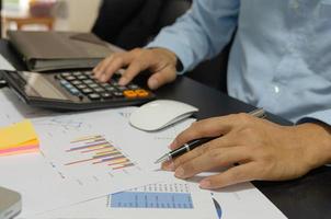 Businessman holding pen, financial, tax, marketing documents photo