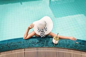 mujer en traje de baño se está relajando en la piscina foto