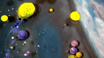 esferas de tinta de colores sobre una superficie lechosa