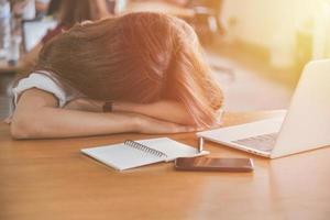 mujer cansada durmiendo en su escritorio foto