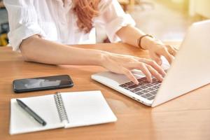 Young businesswoman using laptop on her desk photo