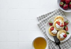 Cottage cheese pancakes, ricotta fritters on ceramic plate photo