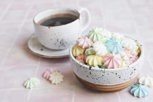 taza con café y pequeños merengues