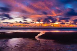 Escena del crepúsculo de la playa asiática con agua que fluye y nubes. foto