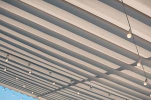 White roofing of terrace, bulbs hanging under the awning photo