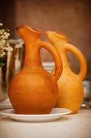 Soft focused wine jugs of terracotta color on the table, family restaurant, lunchtime, simple style