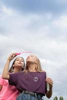 Two girlfriends blowing soap bubbles - carefree and fun photo