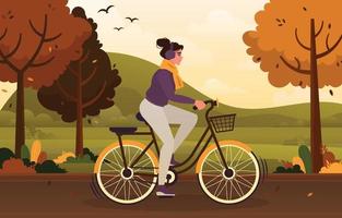 una niña monta una bicicleta en la temporada de otoño