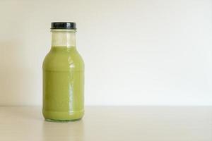 Matcha green tea latte in glass bottle photo