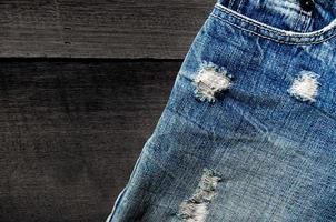 Blue jeans lack and jeans texture on the wooden floor photo