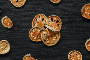 Dried herbs and dried bael fruit, Slices of bael fruit on table. photo